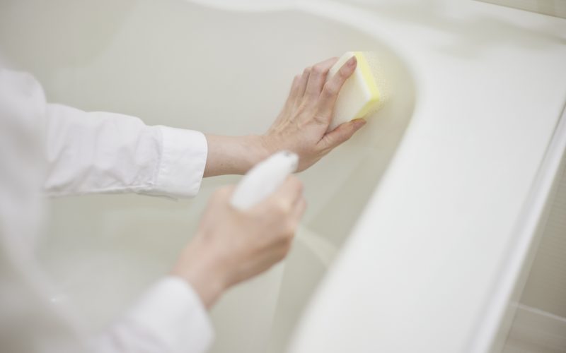 The hands of a housewife cleaning the bath