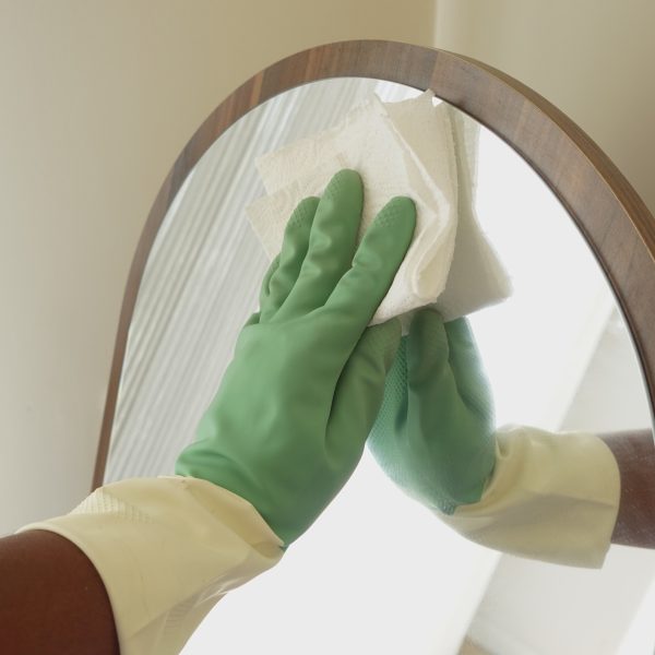 Man Cleaning a home Mirror with a tissue